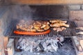 Grilling chicken wings, wurst and other meat on barbecue grill Royalty Free Stock Photo