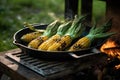 grilling corn on the cob in a cast iron pan on a bbq