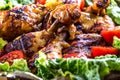Grilling. Grilled chicken. Grilled chicken legs. Grilled chicken legs, lettuce and cherry tomatoes. Traditional cuisine. Royalty Free Stock Photo