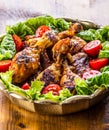 Grilling. Grilled chicken. Grilled chicken legs. Grilled chicken legs, lettuce and cherry tomatoes. Traditional cuisine. Royalty Free Stock Photo