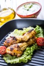 Grilling. Grilled chicken. Grilled chicken legs. Grilled chicken legs, lettuce and cherry tomatoes. Traditional cuisine. Royalty Free Stock Photo