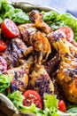 Grilling. Grilled chicken. Grilled chicken legs. Grilled chicken legs, lettuce and cherry tomatoes. Traditional cuisine. Royalty Free Stock Photo