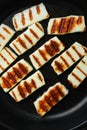 Grilling Halloumi Cheese, on old dark rustic table background, top view flat lay Royalty Free Stock Photo