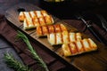 Grilling Halloumi Cheese, on old dark  wooden table background Royalty Free Stock Photo