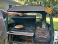 Grilling homemade pizza inside half of a Volkswagen Beetle