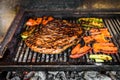 Grilling marinated angus beef flank steak on hot coals barbecue grill Royalty Free Stock Photo