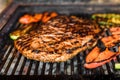 Grilling marinated angus beef flank steak on hot coals barbecue grill Royalty Free Stock Photo