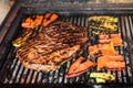 Grilling marinated angus beef flank steak on hot coals barbecue grill