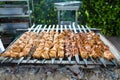 Grilling marinated shashlik on a grill. Shish kebab. BBQ, barbecue on the background of green spaces Royalty Free Stock Photo