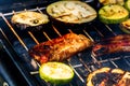 Grilling meat rolls called mici or mititei with vegetables on char barbecue. Charcoal grill with burning fire Royalty Free Stock Photo