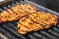 Grilling pork steaks. Delicious juicy meat steaks cooking on the grill Royalty Free Stock Photo
