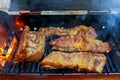 grilling ribs over flaming grill pork ribs on a grill a wood fire Royalty Free Stock Photo