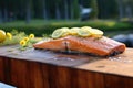 grilling salmon with lemon slices on cedar plank