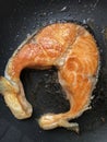 Grilling salmon steak in a pan