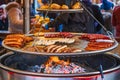 Grilling sausages on barbecue grill at Christmas market in Hyde Park Winter Wonderland