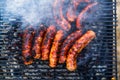 Grilling sausages on barbecue grill. Delicious sausages on charcoal grill