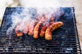 Grilling sausages on barbecue grill. Delicious sausages on charcoal grill