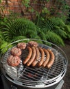 Grilling sausages and beefburgers on a charcoal grill Royalty Free Stock Photo