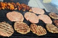 Grilling sausages, burgers, pork steak on barbecues gas grill for party. Hot dogs,sausages and hamburgers on a barbeque, bbq. Smok Royalty Free Stock Photo