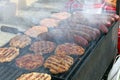 Grilling sausages, burgers, pork steak on barbecues gas grill for party. Hot dogs,sausages and hamburgers on a barbeque, bbq. Smok Royalty Free Stock Photo