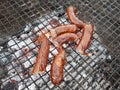 Grilling sausages on the grill. Frying food on charcoal and on fire. Fatty food. Calories and energy for muscles. Picnic on the st Royalty Free Stock Photo