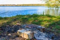 Grilling sausages in portable barbecue grill on campfire at riverbank Royalty Free Stock Photo