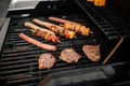 Grilling sausages and skewers on a barbecue Royalty Free Stock Photo