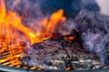 Grilling steaks on flaming gril