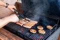 Grilling at summer weekend. Fresh meat preparing on grill.Man hand at a barbecue grill preparing meat for a garden party Royalty Free Stock Photo