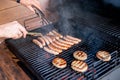 Grilling at summer weekend. Fresh meat preparing on grill.Man hand at a barbecue grill preparing meat for a garden party Royalty Free Stock Photo