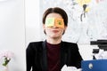Grimacing businesswoman sitting with stickers on eyes Royalty Free Stock Photo