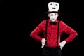 grimacing mime with hands akimbo and mask on hat