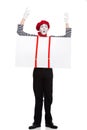 grimacing mime holding empty board under suspenders with hands up