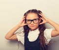 Grimacing pupil girl with long hair style in fashion eyeglasses in uniform making dreaming physiognomy Royalty Free Stock Photo