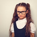 Grimacing pupil girl with long hair style in fashion eyeglasses in uniform squint eyes