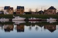 Grimbergen, Flemish Brabant Region, Belgium - Residential houses in a row and boats reflecting in the water of the canal at dusk Royalty Free Stock Photo