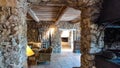 View into room of french cottage built of natural materials in style prevencale with stone wall and wood ceiling