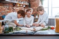 Grimy boys with kitchen equipment learning to cook pizza together Royalty Free Stock Photo