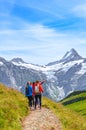 Grindelwald, Switzerland - August 16, 2019: Summer Alpine landscape. Young Female travellers and Swiss Alps in the background.