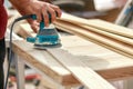 Grinder worker polishes a wooden board. Sanding boards Orbital eccentric machine. Royalty Free Stock Photo