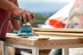 Grinder worker polishes a wooden board. Sanding boards Orbital eccentric machine. Royalty Free Stock Photo