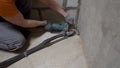 A worker smoothest the floor with an angle grinder. Grinding a concrete floor with a grinding machine before repair. A