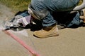 Grinding the edge of a heaved sidewalk Royalty Free Stock Photo