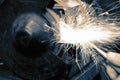 Grinding metal with an electric grinder machine with sparks in a workshop