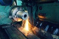 Grinding of metal, final processing of a part on a precision grinding machine with sparks and cooling.