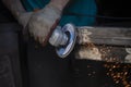 Grinding of metal. Sparks from power tools. The man works in the garage