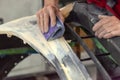 Grinding a part of the vehicle bumper with the hands of a professional master using sandpaper and primer using the technology in