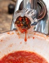 Grinding tomatoes through a meat grinder Royalty Free Stock Photo