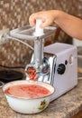 Grinding tomatoes through a meat grinder Royalty Free Stock Photo