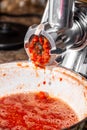 Grinding tomatoes through a meat grinder Royalty Free Stock Photo